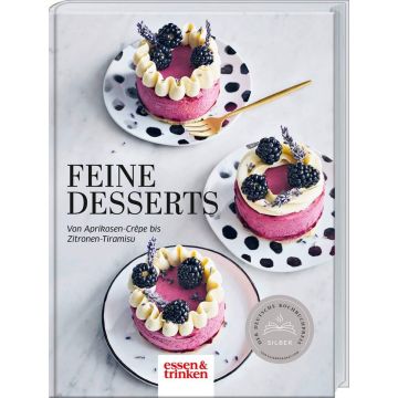 Buchcover: "Feine Desserts". Drei Himbeertörtchen mit Brombeeren und Sahne auf gepunkteten Tellern, verziert mit Lavendel. Text: "Von Aprikosen-Crêpe bis Zitronen-Tiramisu". Logo: essen & trinken.